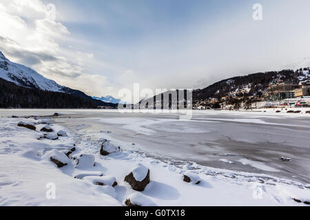 Vue imprenable sur les eaux glacées du lac de Saint-Moritz et la ville sur la montagne en hiver, Canton des Grisons, Suisse Banque D'Images