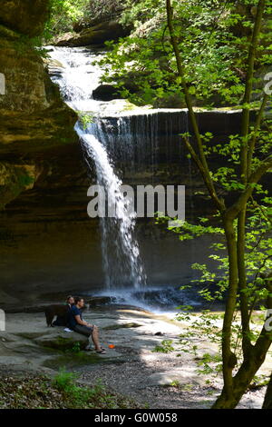 Les randonneurs avec un chien se reposant à la cascade dans la salle Canyon à Starved Rock State Park sur les rives de la rivière Illinois. Banque D'Images