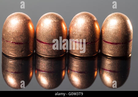 Balles de pistolet avec réflexion sur un fond gris Banque D'Images