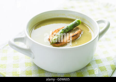 Libre d'asperges soupe dans un bol blanc avec tranche de pain et d'asperge sur le dessus Banque D'Images