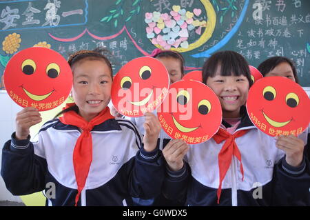 4 mai 2016 - Donghai, Donghai, CHN - Donghai, CHINE - 4 mai 2016 : (usage éditorial uniquement. Chine ) Les élèves d'école primaire Linian ont une plaisanterie la concurrence et sélectionnez smile ambassadors pour célébrer la Journée mondiale de sourire. Elle est célébrée le premier vendredi du mois d'octobre de chaque année. L'idée de monde sourire jour a été inventé et lancé par Harvey Ball, un artiste commercial de Worcester, Massachusetts. Harvey Ball est connu pour avoir créé le Smiley en 1963. La première Journée mondiale de sourire a eu lieu en l'année 1999 et a lieu chaque année depuis. Après Harvey est mort en 2001, le ''Har Banque D'Images