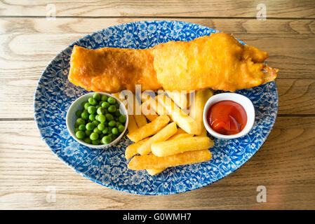 Fish & Chips avec les pois et le ketchup, repas dans un pub, au Royaume-Uni. Banque D'Images