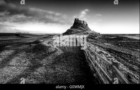 Aux limites de la Crooked menant jusqu'au magnifique château de Lindisfarne, avec les veilleuses casting shadows de la clôture sur le terrain. Banque D'Images