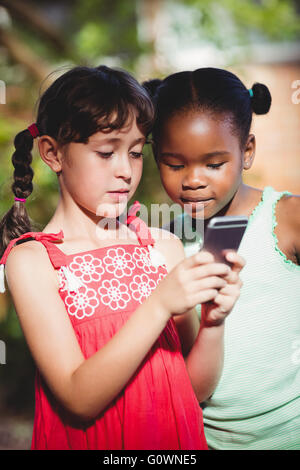 Deux jeunes filles à la recherche à un smartphone Banque D'Images
