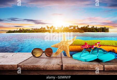 Accessoires de plage pour voyager placés sur des planches. Tropical Beach sur l'arrière-plan Banque D'Images