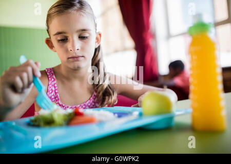 Enfant mangeant à la cantine Banque D'Images