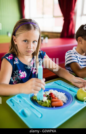 Enfant mangeant à la cantine Banque D'Images