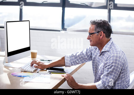 Vue de profil d'un businessman working on computer Banque D'Images