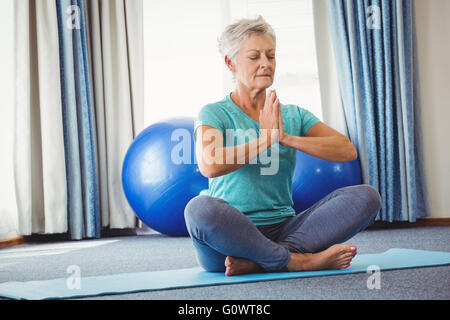 Portrait of senior woman sitting in lotus position Banque D'Images