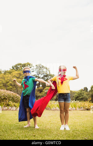 Face à des enfants vue wearing superhero costume posant pour l'appareil photo Banque D'Images