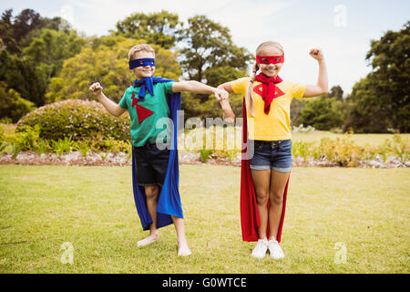 Face à des enfants vue wearing superhero costume posant pour l'appareil photo Banque D'Images