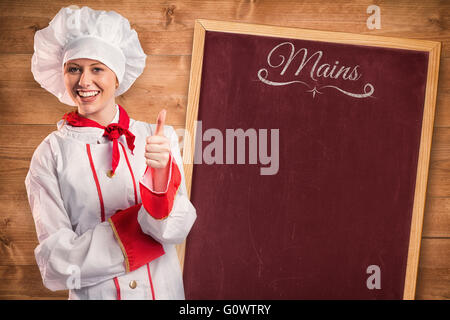 Image composite de jolie chef showing Thumbs up Banque D'Images