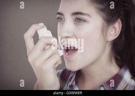 Image composite d'une femme souffrant d'asthme à l'aide de l'inhalateur d'asthme Banque D'Images