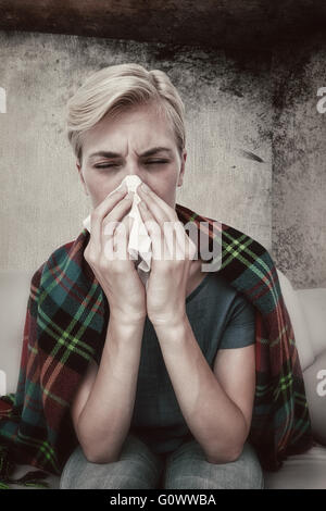 Image composite de malade blonde woman blowing her nose Banque D'Images