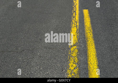 Grunge jaune Double ligne sur route asphaltée. Banque D'Images