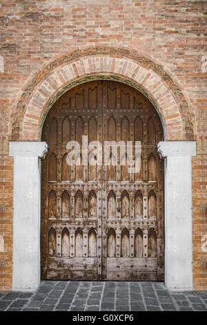 Entrée voûtée d'un palais médiéval avec porte en bois sculpté. Banque D'Images