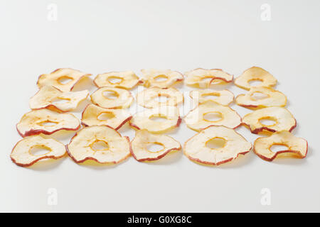Les morceaux de pommes séchés classés sur fond blanc Banque D'Images