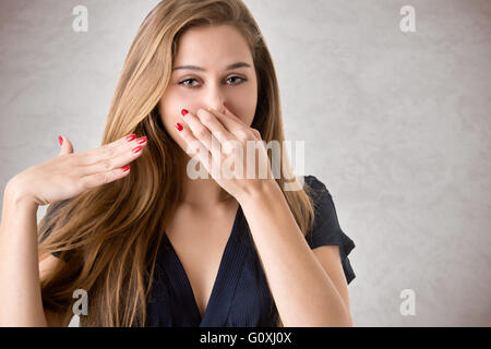 Femme couvrant son nez avec sa main, isolé Banque D'Images