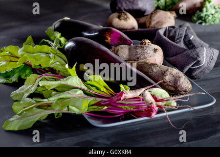 Les betteraves rouges, les aubergines et les feuilles de betterave sur la plaque sur tableau noir Banque D'Images