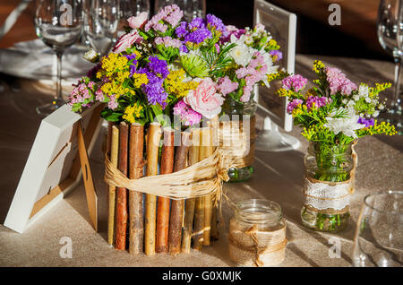 Table rustique mariage plein de fleurs sauvages et et décoration pays Banque D'Images