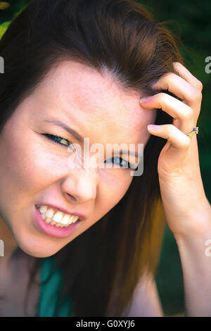 Portrait d'une femme en colère frustrée en dehors serrant ses dents Banque D'Images