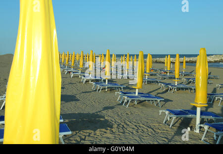 Fermé jaune avec parasols, chaises longues et transats Banque D'Images
