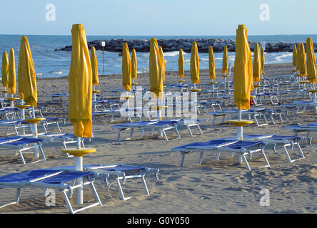 Fermé jaune avec parasols, chaises longues et transats Banque D'Images