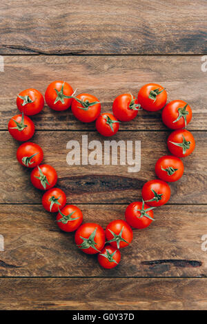 Tomates cerises mûres disposées en forme de coeur Banque D'Images