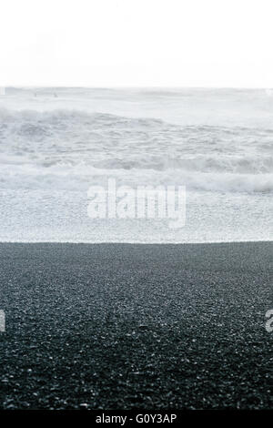 Cailloux noir et blanc des vagues sur une plage en Islande Banque D'Images