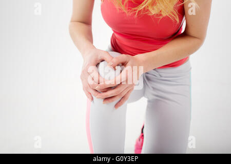 Close-up of woman holding vêtements fitness dans l'athlète dans la douleur au genou Banque D'Images