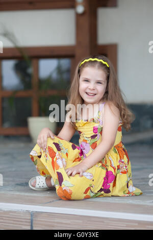 Portrait of a smiling girl sitting on terrace Banque D'Images