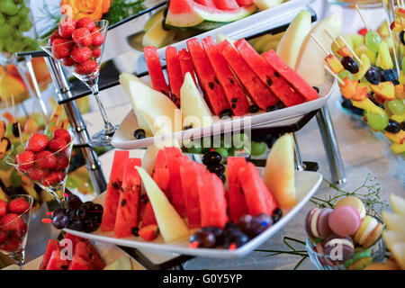 Plaques avec différents types de fruits : raisins, fraises, ananas, pastèque, abricots Banque D'Images