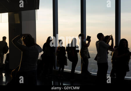 Les touristes et les visiteurs d'admirer la vue depuis le One World Trade Center Observatory juste avant le coucher du soleil Banque D'Images