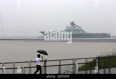 Nantong. 6 mai, 2016. Un piéton montres porte-avion Minsk en Nantong, Province du Jiangsu en Chine de l'Est, le 5 mai 2016. Minsk seront construites dans le nouveau parc à thème à Nantong. Minsk a servi la marine soviétique, et plus tard la marine russe, de 1978 à 1994. De 2000 à 2016 il a été un parc à thème appelé monde Minsk dans le sud de la Chine, Shenzhen. Source : Xinhua/Alamy Live News Banque D'Images