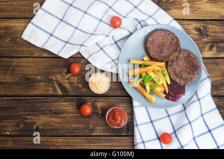 Deux hamburgers de boeuf avec des frites sur la table en bois avec vue de dessus Banque D'Images