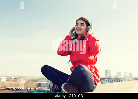 Happy young woman in headphones listening to music Banque D'Images