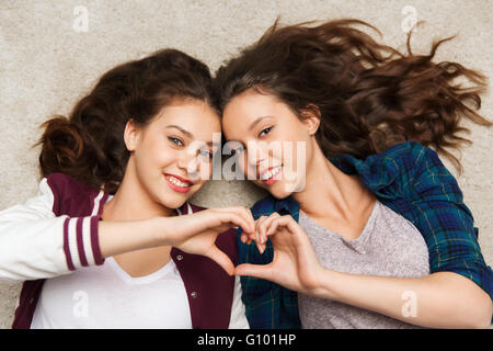 Happy smiling pretty teenage girls lying on floor Banque D'Images