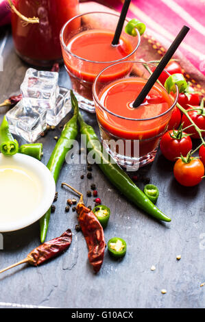 Jus de tomates fraîches avec tomates cerises et de piment sur fond rustique Banque D'Images