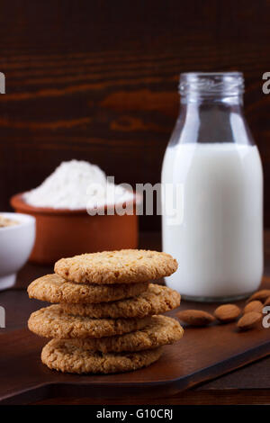 Les cookies d'avoine fait maison et les ingrédients pour la cuisson sur planche de bois rustique Banque D'Images