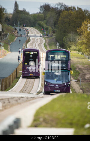 Deux bus à impériale passant sur le nouveau béton busway guidé Banque D'Images