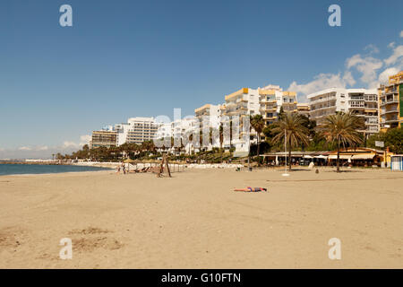 Sur Sunbather Playa de la Bajadilla, la plage de Marbella, Costa del Sol, Andalousie, Espagne Europe Banque D'Images