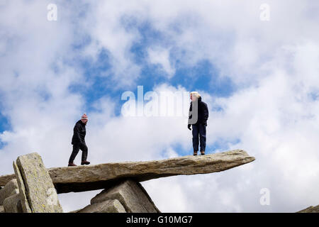 Deux randonneurs debout sur rock Glyder Fach cantilever sur Glyderau en montagnes de Snowdonia National Park Galles Royaume-uni Grande-Bretagne Banque D'Images