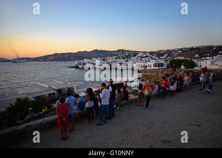 Les personnes bénéficiant d'une vue sur la ville de Mykonos, Grèce, au coucher du soleil Banque D'Images