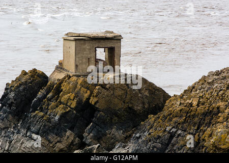 La défense abandonnés post sur la côte. Une station d'armes à feu en béton se dresse sur des rochers sur la rive de la Canal de Bristol, dans le Somerset Banque D'Images