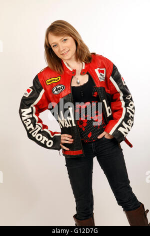 Jeune femme aux cheveux blonds dans une veste de moto en cuir vintage avec logos Banque D'Images