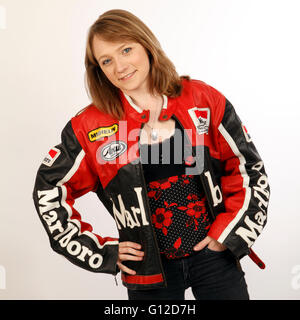 Jeune femme aux cheveux blonds dans une veste de moto en cuir vintage avec logos Banque D'Images