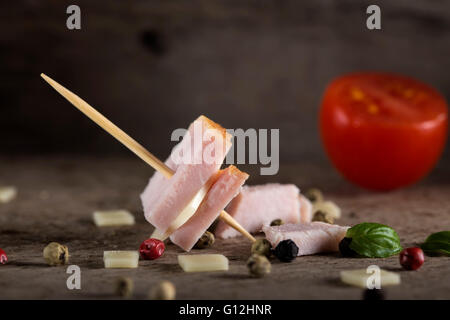 Mini jambon et fromage apéritif avec des épices sur fond de bois Banque D'Images