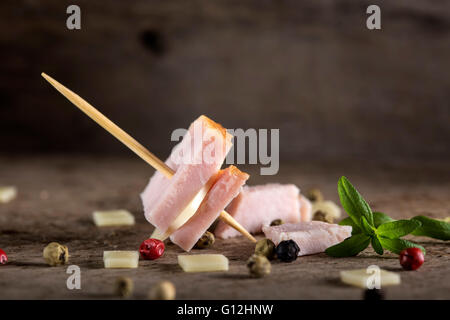 Mini jambon et fromage apéritif avec des épices sur fond de bois Banque D'Images