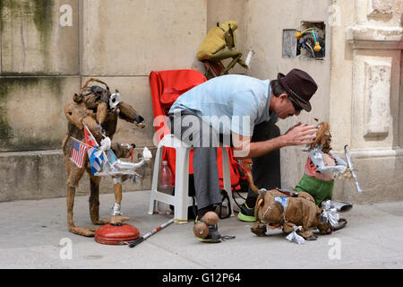 Un artiste de rue prépare ses marionnettes mécaniques pour sa performance dans la Vieille Havane, La Havane, Cuba Banque D'Images