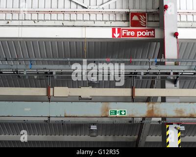 Point d'incendie et le feu des enseignes de sortie sur des poutres en acier dans l'entrepôt Banque D'Images